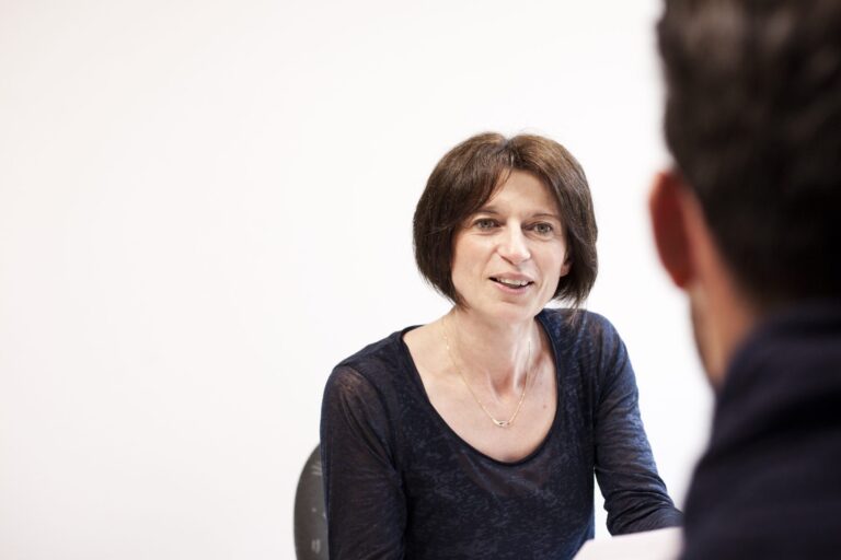 Conseillère en assurance avec un client devant elle pour lui expliquer l'assurance