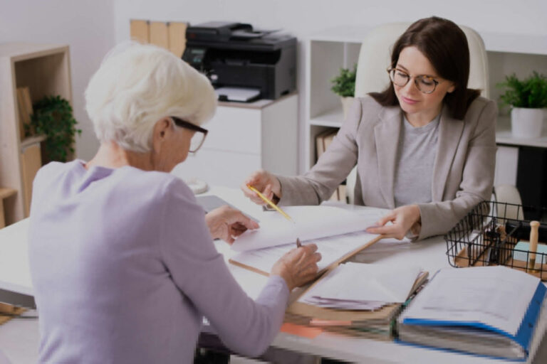 Une femme conseillère tient des document et les explique à une dame un peu plus âgée