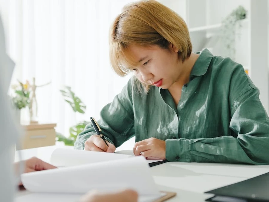 Une femme assise à une table rempli des documents