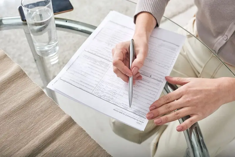 Sur une table une personne complète un dossier